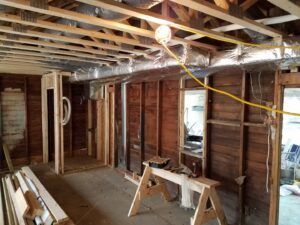 New HVAC ductwork being installed in the ceiling of a residential construction project by Shook Heating And Cooling in Livonia, MI.
