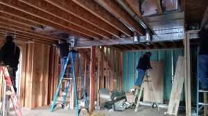 HVAC technicians installing large rectangular ductwork in a new construction building by Atmosphere Mechanical Heating And Air / Ventilation in Aurora, CO.