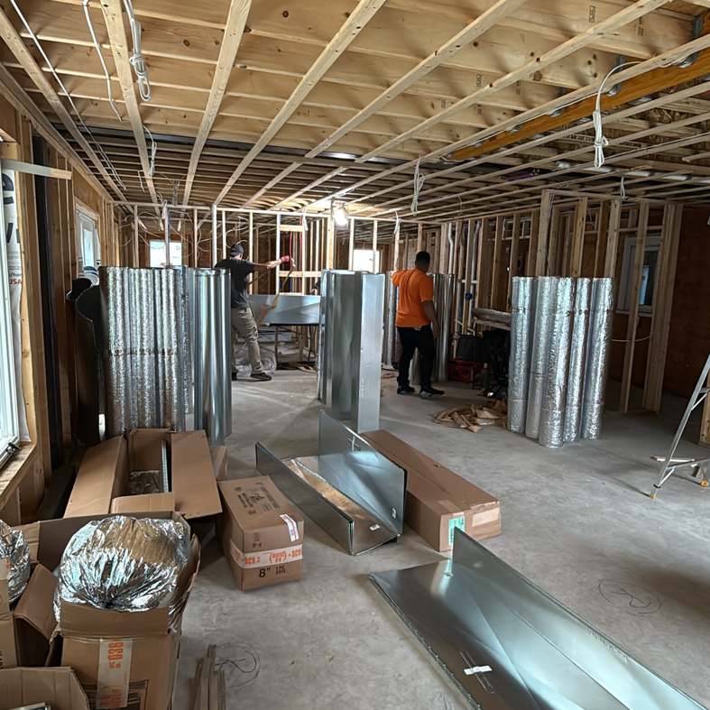 HVAC technicians installing ductwork in a new construction home by Massachusetts Pro HVAC in Shrewsbury, MA.