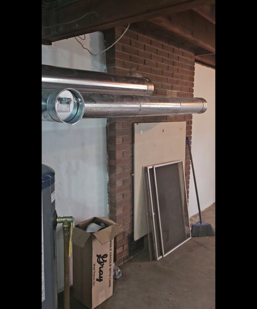 Newly installed metal HVAC ductwork running along a basement ceiling by NewEra Mechanical LLC in New Britain, CT