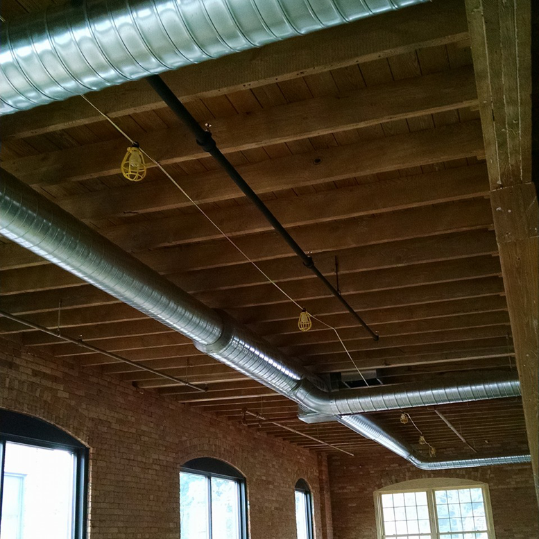 Newly installed spiral HVAC ductwork in a commercial building by SM Heating and Cooling in Rochester, NY