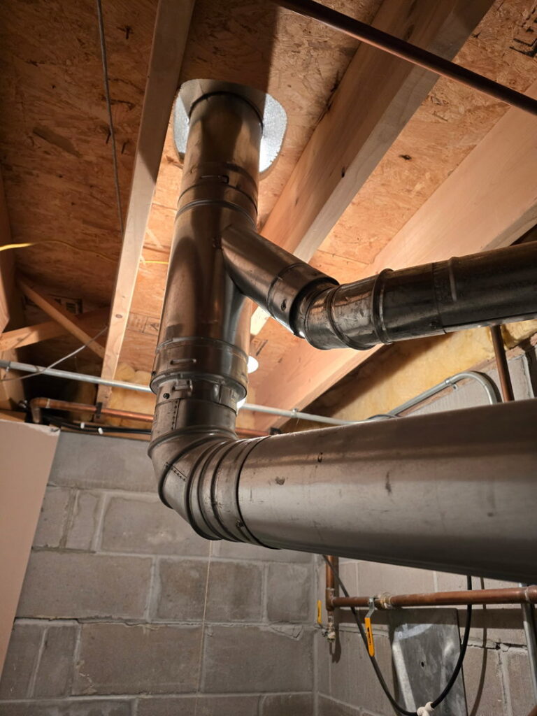 Metal HVAC ductwork and piping installed through a ceiling by Jackson Home Appliance Heating & Cooling in Omaha, NE