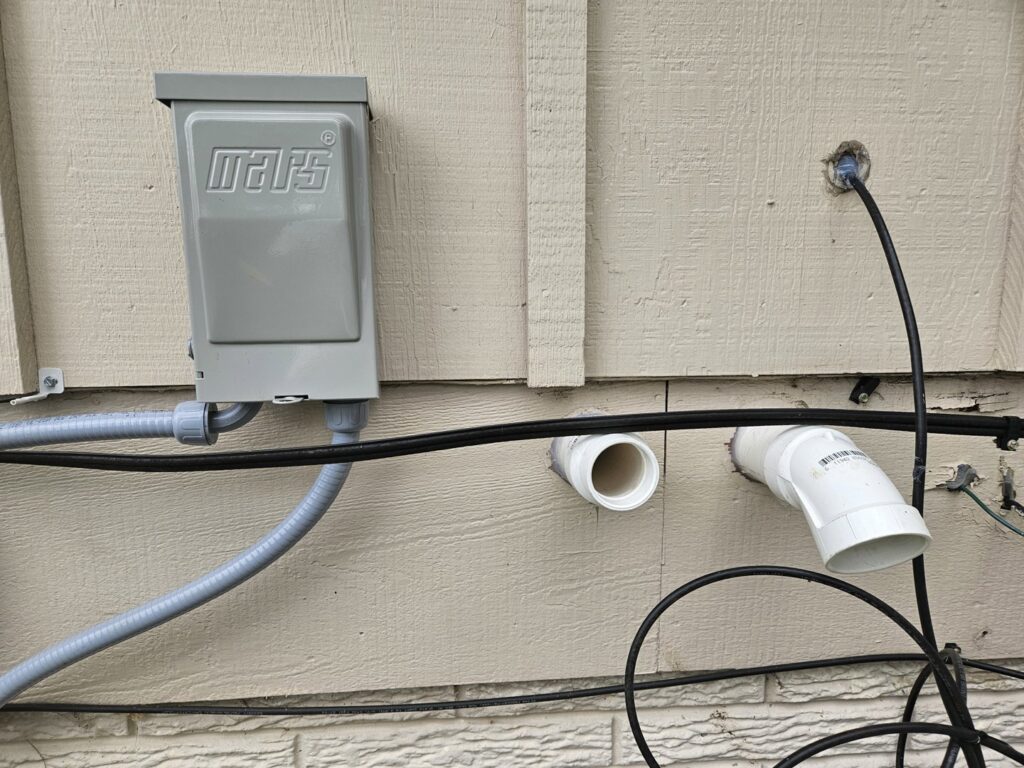 Newly installed electrical conduit and PVC drainage lines for an HVAC system by Great Lakes Heating & Air Conditioning in Wickliffe, OH.