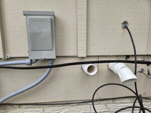 Newly installed electrical conduit and PVC drainage lines for an HVAC system by Great Lakes Heating & Air Conditioning in Wickliffe, OH.
