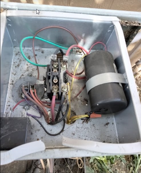 An open electrical box of an HVAC unit showing wiring and a capacitor, indicating service by Desert Air, LLC in Sun Valley, NV.