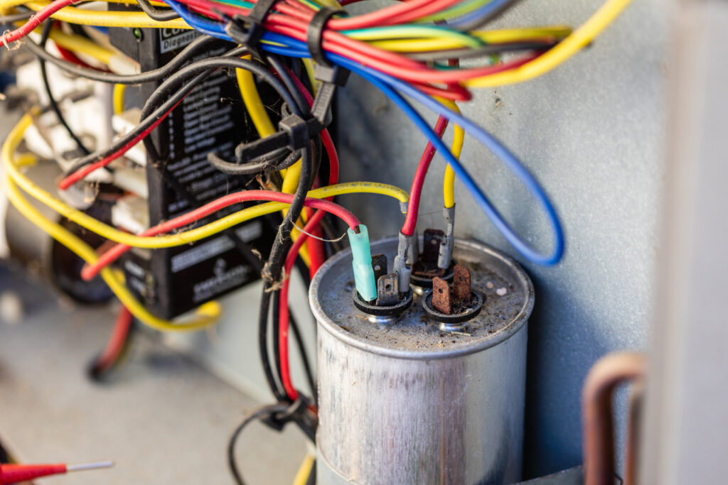 Close-up of HVAC electrical components, including a capacitor and wiring, serviced by Surfside Heating & Cooling in Cape Coral, FL.