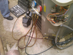 Close-up of the electrical components and wiring inside an outdoor AC unit being serviced by J AND J HVAC L.L.C in Mesa, AZ