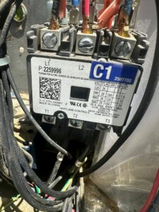 A close-up of an electrical contactor or relay component within an HVAC system, indicating repair by Air Casablanca Heating & Cooling in Myrtle Beach, SC.