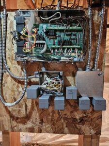 An open electrical control panel for an HVAC system, showing circuit boards and wiring by Perfect Temp LLC in Bozeman, MT.