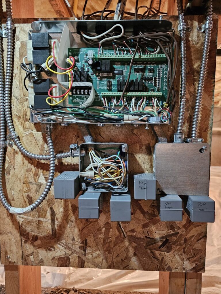 An open electrical control panel for an HVAC system, showing circuit boards and wiring by Perfect Temp LLC in Bozeman, MT.