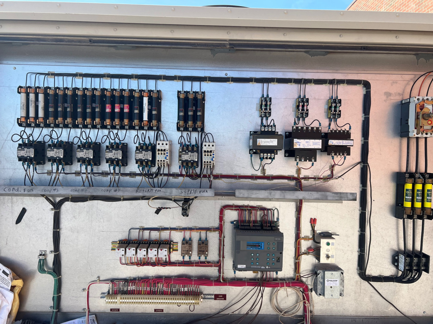 An open electrical control panel showing wiring and components for an HVAC system by Evans Heat & Air in Ruther Glen, VA.
