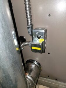 Close-up of electrical wiring and conduit connections on an HVAC unit, showing detailed work by Family First Heating and Cooling Repair LLC in Toledo, OH.