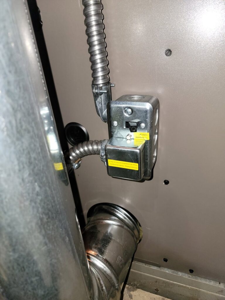 Close-up of electrical wiring and conduit connections on an HVAC unit, showing detailed work by Family First Heating and Cooling Repair LLC in Toledo, OH.