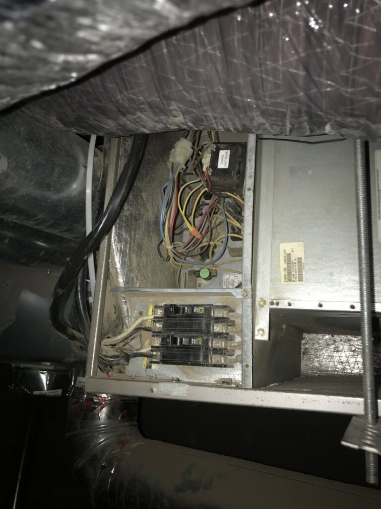 Close-up of electrical wiring and circuit breakers inside an HVAC unit being serviced by Warren Mechanical, LLC in Carmel, IN.