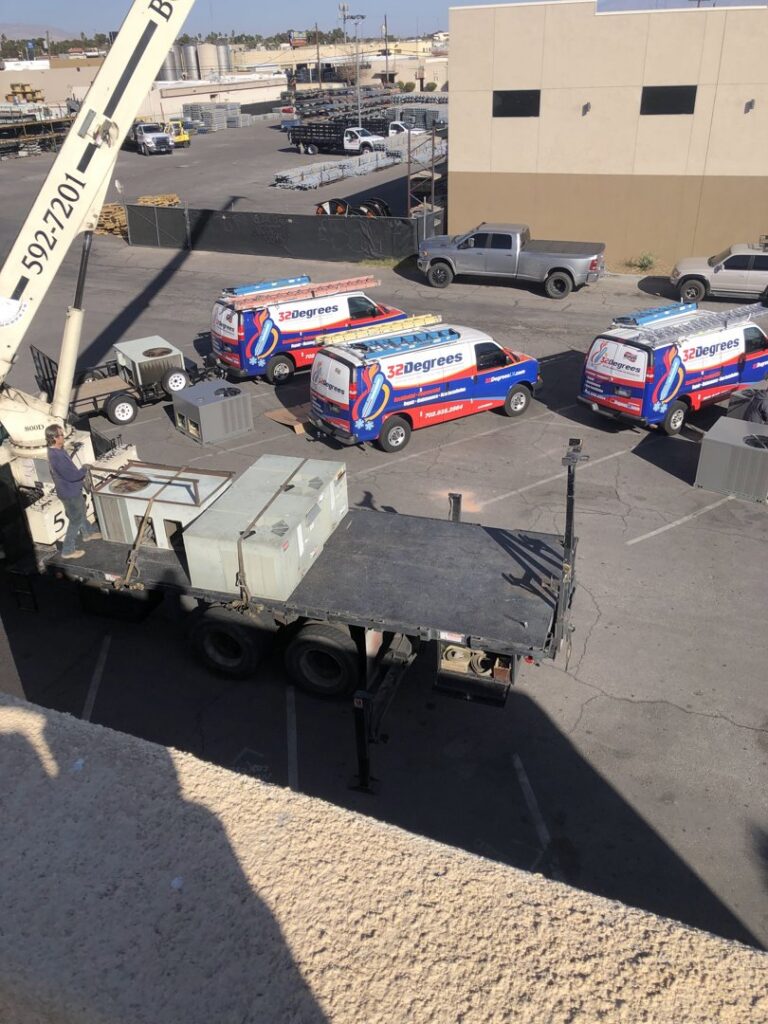 HVAC equipment being delivered by crane with company vans from 32 Degrees Heating and Air Conditioning in Las Vegas, NV