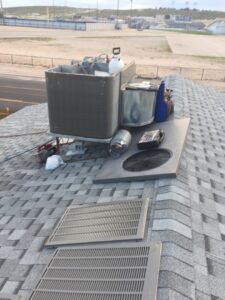 Various HVAC equipment and tools on a rooftop, indicating service or installation work by Carlsbad Heating & Cooling in Carlsbad, NM.