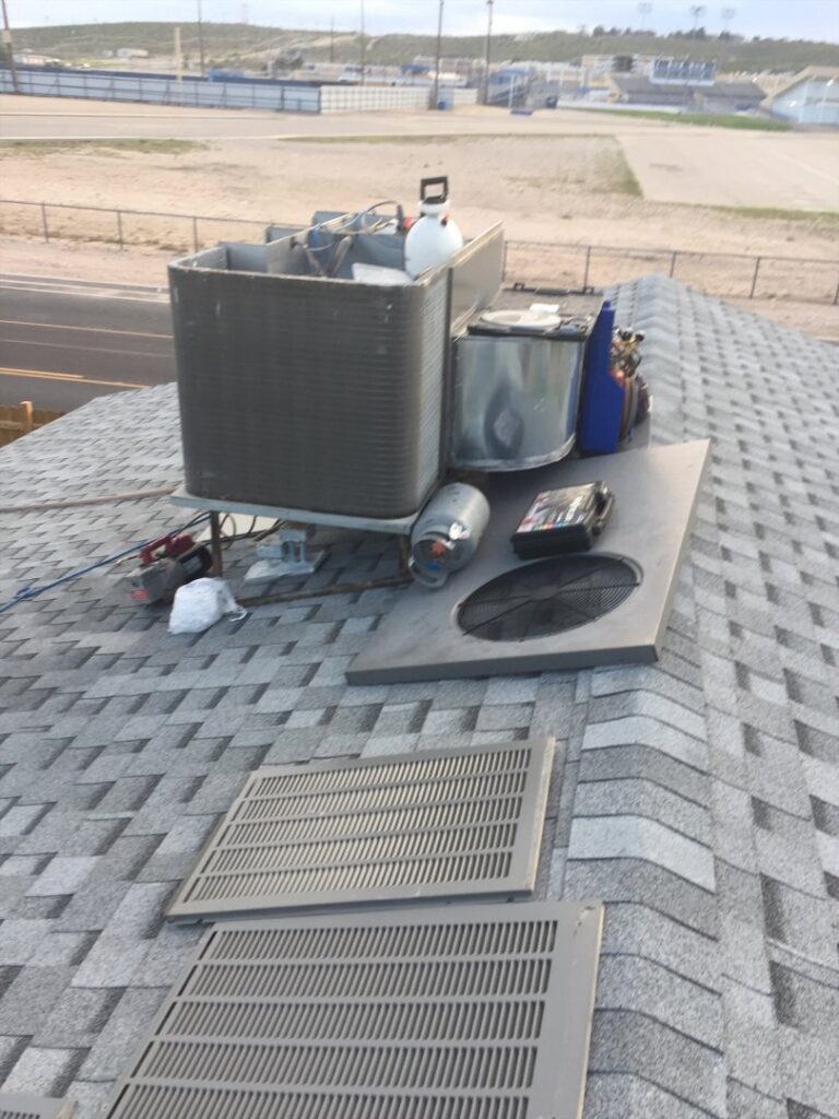 Various HVAC equipment and tools on a rooftop, indicating service or installation work by Carlsbad Heating & Cooling in Carlsbad, NM.