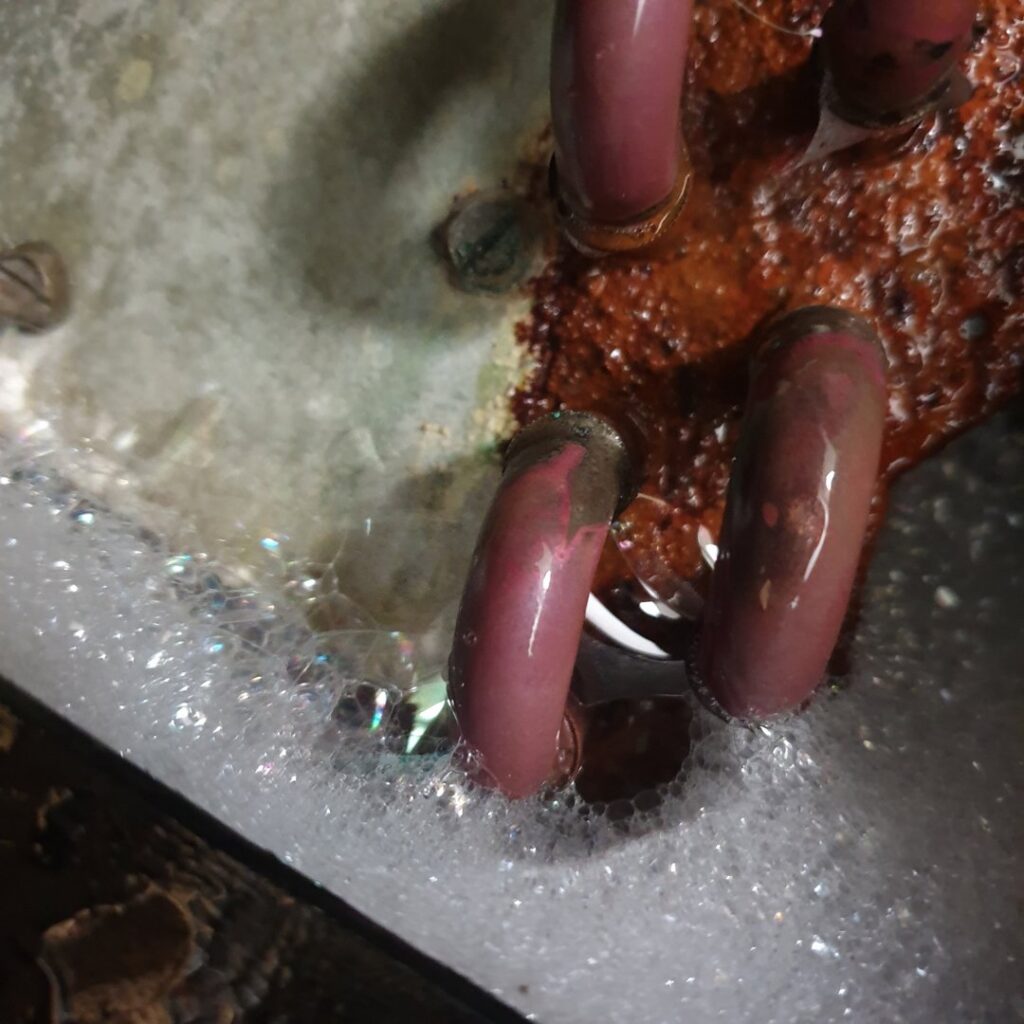 Close-up of HVAC evaporator coils being cleaned with foaming solution by Home Shield Heating and Air in Shreveport, LA.