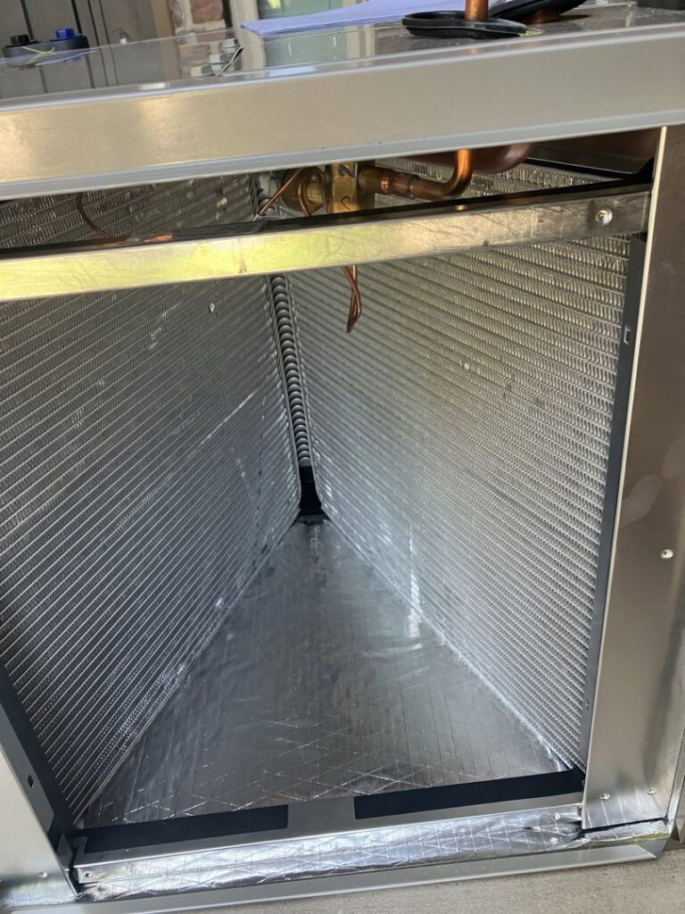 A close-up view of an HVAC evaporator coil inside an air handler, serviced by Blue Sky Heating and Air in Austin, TX.