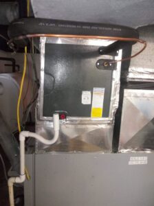 An HVAC evaporator coil installation with condensate drain and refrigerant lines by ReDesign Air in Winchester, VA.