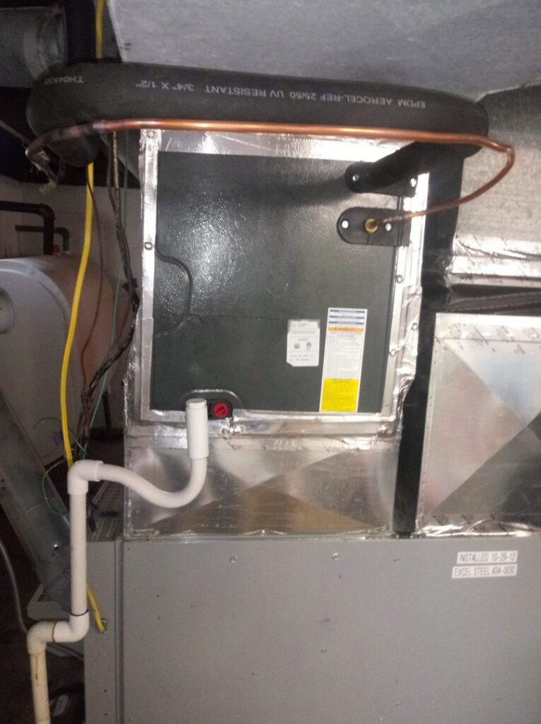 An HVAC evaporator coil installation with condensate drain and refrigerant lines by ReDesign Air in Winchester, VA.