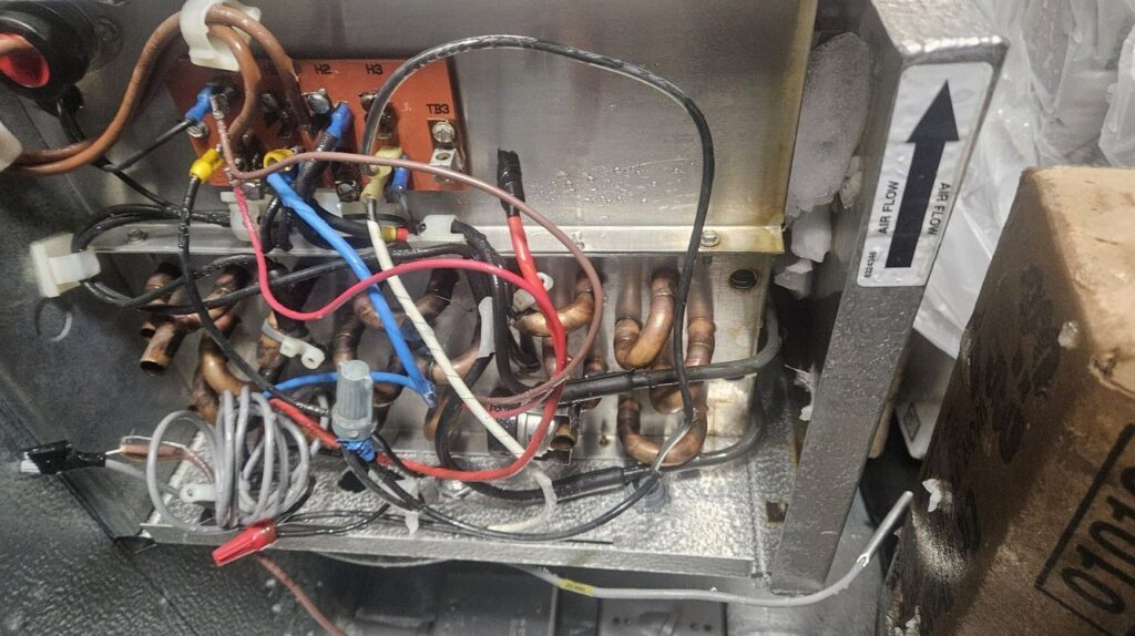 A close-up of an HVAC evaporator coil with wiring and copper lines by Will Power Refrigeration Co in Yonkers, NY.