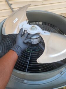 A technician replacing an HVAC fan blade at a job site for Comfort Zone Mechanical in Antioch, TN.
