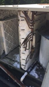 An HVAC filter next to an iced coil inside a unit, requiring repair from Raleigh Comfort Services in Raleigh, NC.