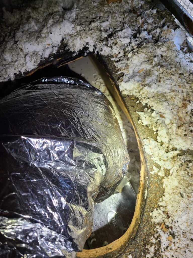 Close-up of a round HVAC ductwork opening in a ceiling, showing insulated flexible ducting by Rivertech Heating & Air Conditioning in Chattanooga, TN.