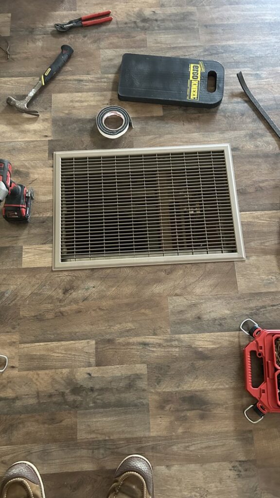 HVAC floor vent surrounded by tools, indicating repair or installation work by Service Kings Heating and Air in Jamestown, ND.