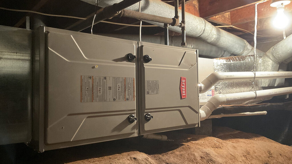 An HVAC furnace or air handler with connected ductwork installed in a crawl space by Top Notch Heating and Air Conditioning in Bowling Green, KY.