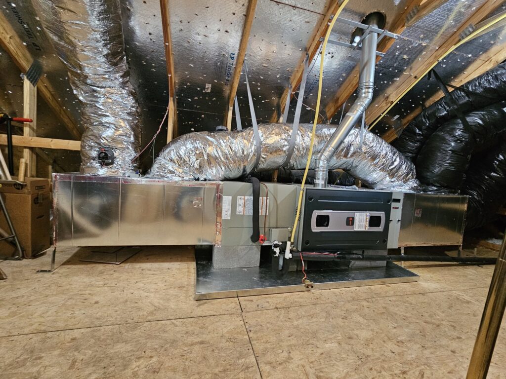 An HVAC furnace and air handler unit with ductwork installed in an attic by Modern Mechanical HVAC in Garner, NC.