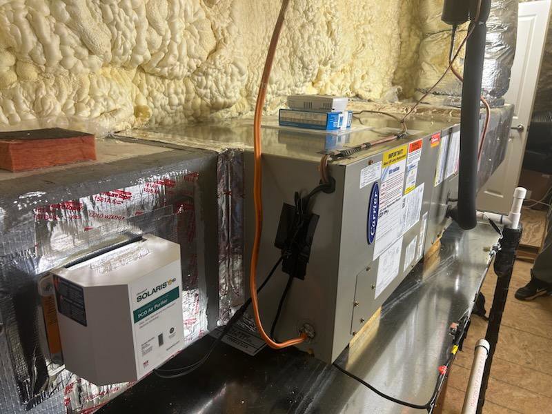 An indoor HVAC furnace or air handler unit with ductwork and insulation, installed by Heads Heating & Air Conditioning in Theodore, AL.