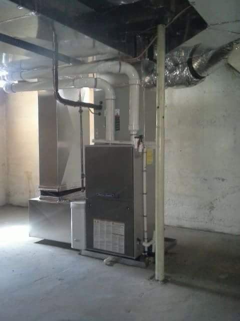 An HVAC furnace and air handler unit with ductwork installed in a basement by ReDesign Air in Winchester, VA.