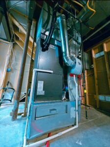 An HVAC furnace and extensive ductwork installed in a utility area by Cool y Caliente HVAC Services in Bonner Springs, KS.