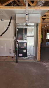 A Goodman HVAC furnace and large round metal ductwork installed in a new construction home by Integrity Heating And Air LLC in Nampa, ID