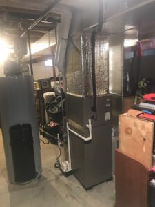 An HVAC furnace and water heater system in a basement by Quality Comfort Inc. in Aston, PA