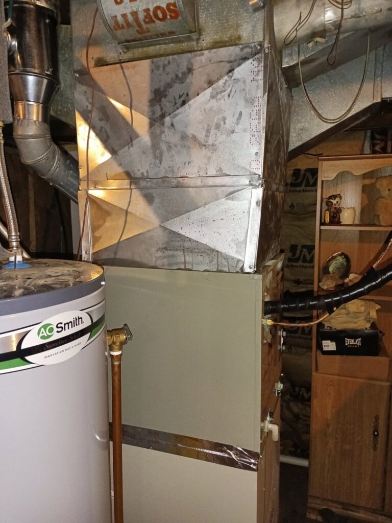 An HVAC furnace unit installed next to a water heater, showing services provided by TAS Mechanical Services in Kearney, MO.