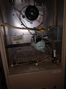 A close-up view of furnace burner components and wiring during an HVAC service by SM Heating and Cooling in Rochester, NY