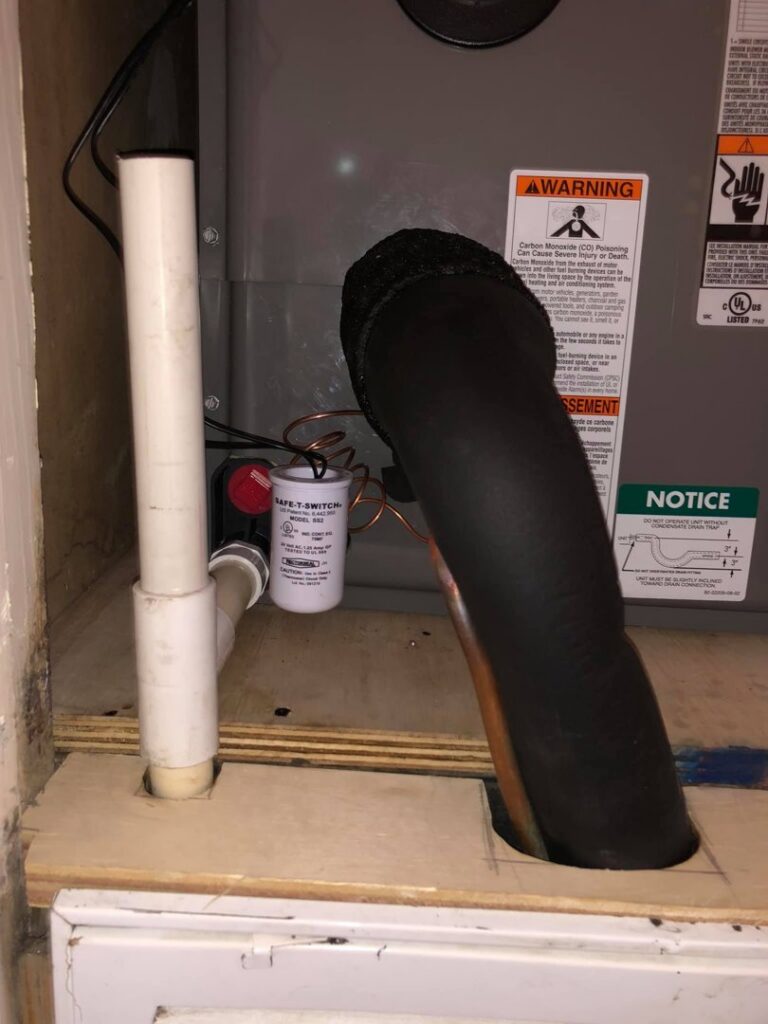Close-up of an HVAC furnace or air handler with a condensate drain line and safety switch, serviced by The A/C Guy in Shreveport, LA.