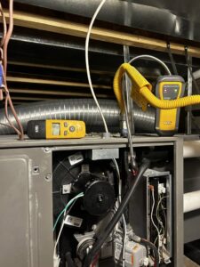 An open furnace with diagnostic tools, showing an HVAC repair in progress by Waymaker HVAC LLC in Colorado Springs, CO.