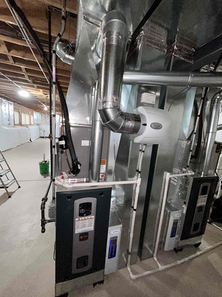A newly installed furnace and humidifier with ductwork in a basement by Air For You Heating and Air in Joliet, IL.