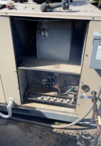 An open rooftop HVAC unit showing furnace components during an inspection by Schomp's Mechanical Services in Brookings, SD.