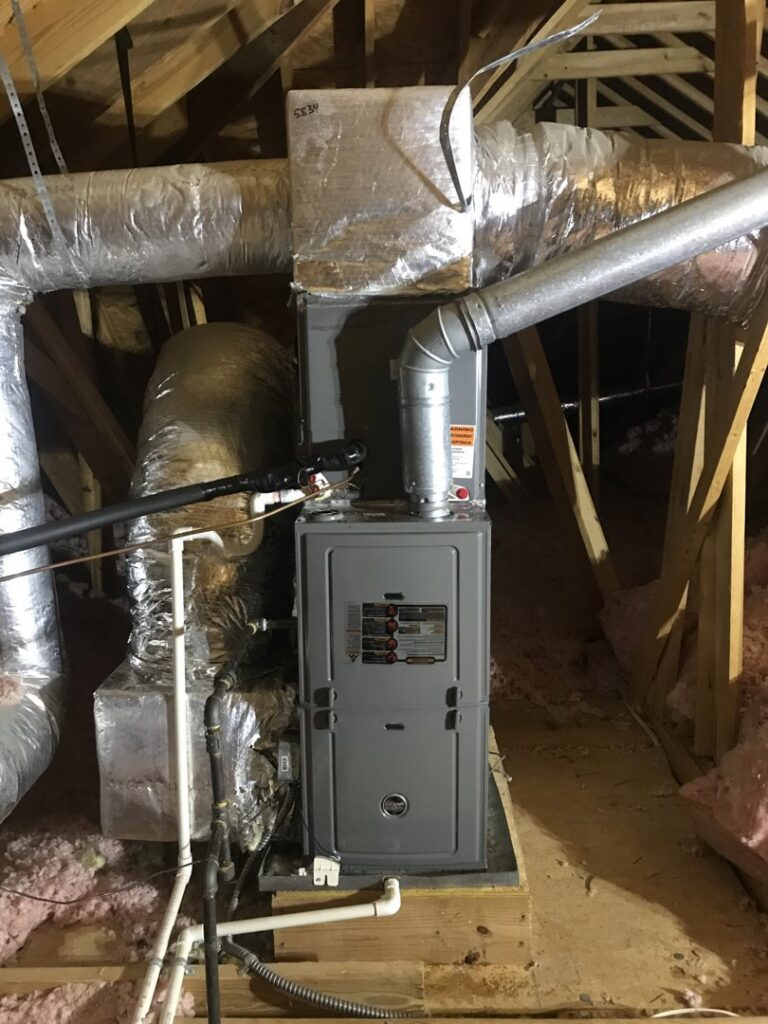 An indoor HVAC furnace and air handler unit with ductwork installed in an attic by Gouker's Best Air in Franklin, TN.