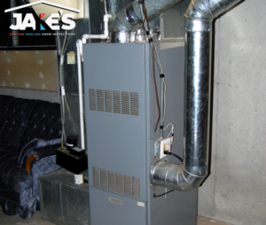 A newly installed HVAC furnace unit with ductwork in a basement by Jake's Heating and Cooling in Buffalo, NY.