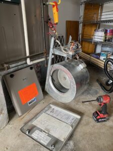 Disassembled furnace components and tools during an HVAC repair by Heatwave Heating & Air LLC in Federal Way, WA.