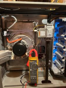 An HVAC technician performing a furnace repair and diagnosis with a multimeter at Sahara Air Conditioning & Heating in Las Vegas, NV