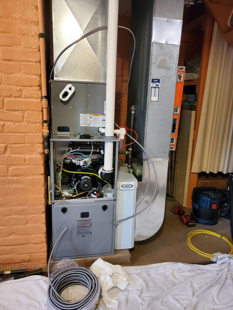 An indoor furnace and air handler unit with an open panel during repair or installation by Bouvy Heating & Air Conditioning Services in Pittsburgh, PA.