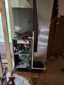 An HVAC technician performing a furnace repair or installation for Medina's Heating & Air Conditioning in Joliet, IL.