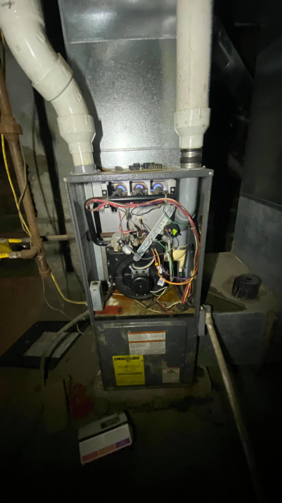 An open HVAC furnace showing internal components during repair or maintenance by Allegheny General Contracting Services Heating and Cooling in Pittsburgh, PA.